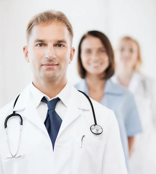 Doctor with stethoscope and colleagues — Stock Photo, Image