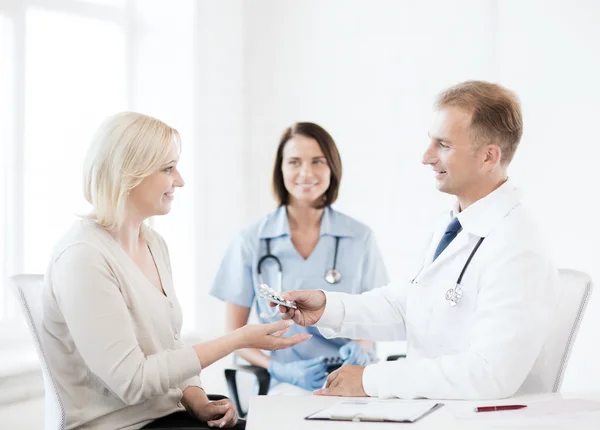 Doctor giving tablets to patient in hospital — Stock Photo, Image