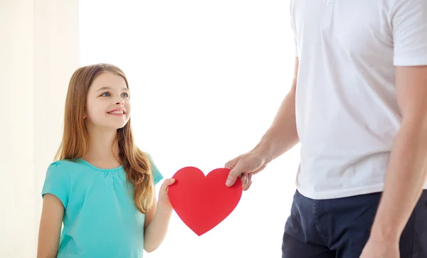 Sonriente niña y padre sosteniendo el corazón rojo —  Fotos de Stock