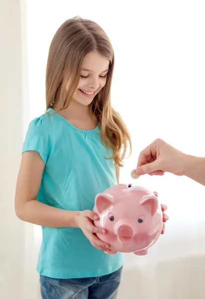 Smiling little girl holding piggy bank — Stock Photo, Image