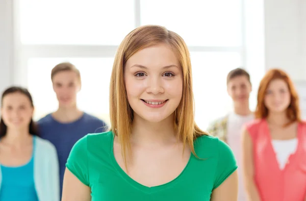 Smiling students with teenage girl in front — Stock Photo, Image