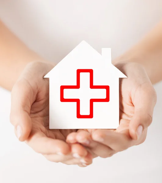 Hands holding paper house with red cross — Stock Photo, Image