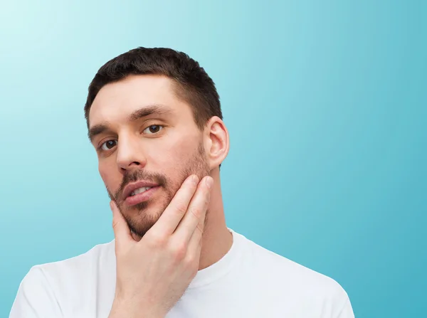 Belo homem calmo tocando seu rosto — Fotografia de Stock