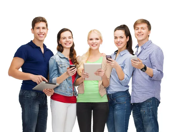 Estudiantes sonrientes usando teléfonos inteligentes y tableta PC — Foto de Stock