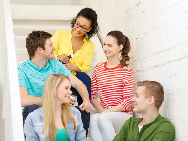 Smiling students with smartphone having discussion — Stock Photo, Image