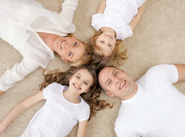 Родители и две девочки, лежащие на полу дома — стоковое фото