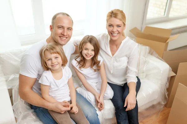 Smiling parents and two little girls at new home — Stock Photo, Image