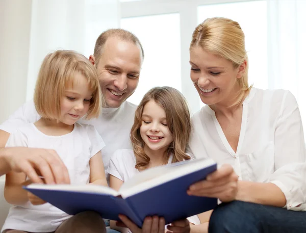 Smilende familie og to små jenter med bok – stockfoto