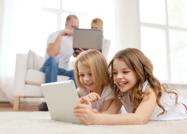 Hermana sonriente con la tableta PC y los padres en la espalda — Foto de Stock