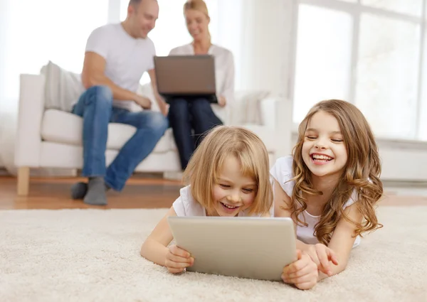 Hermana sonriente con la tableta PC y los padres en la espalda —  Fotos de Stock