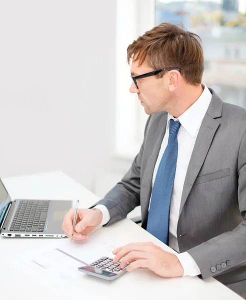 Geschäftsmann mit Computer, Papier und Taschenrechner — Stockfoto