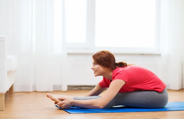 Lachende tienermeisje streching op verdieping thuis — Stockfoto