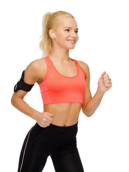 Mujer deportiva corriendo con smartphone y auriculares — Foto de Stock