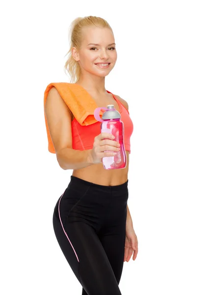 Lächelnde sportliche Frau mit Wasserflasche und Handtuch — Stockfoto