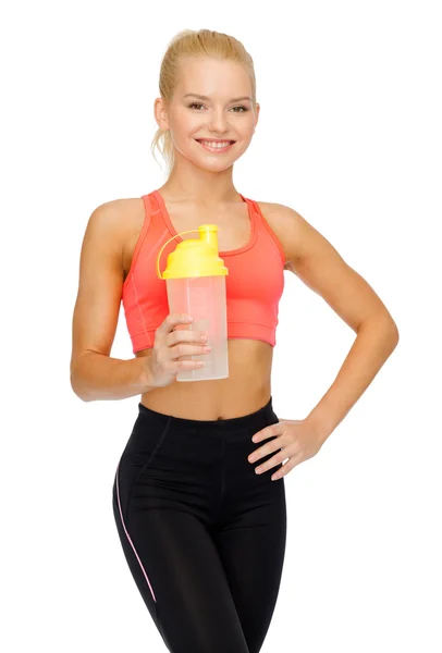 Lächelnde sportliche Frau mit Protein-Shake-Flasche — Stockfoto