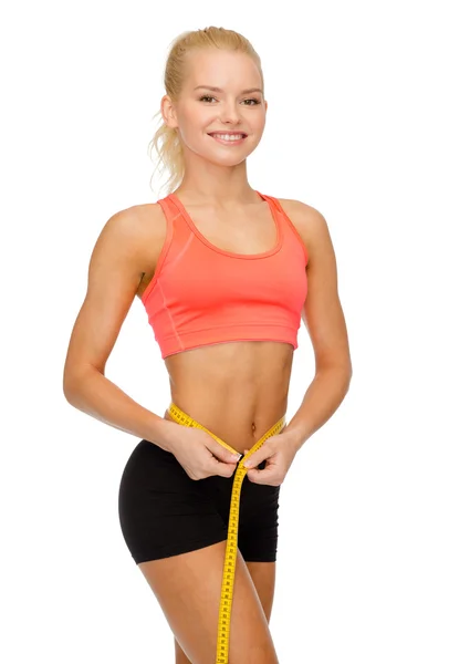 Mujer deportiva sonriente con cinta métrica — Foto de Stock