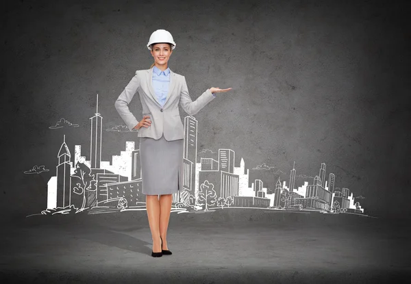 Geschäftsfrau mit Helm hält etwas auf Handfläche — Stockfoto