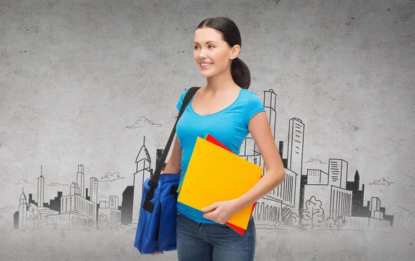 Estudiante sonriente con bolsa y carpetas — Foto de Stock