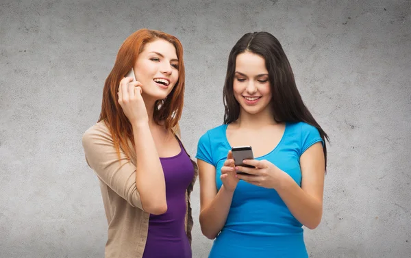 Two smiling teenagers with smartphones — Stock Photo, Image