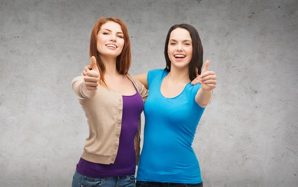 Две улыбающиеся девушки, показывающие большие пальцы вверх — стоковое фото