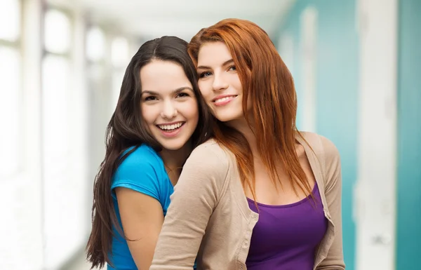 Twee lachende meisjes knuffelen — Stockfoto