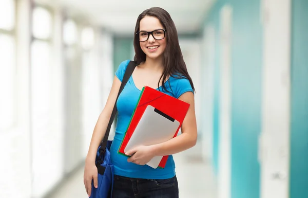 Estudiante sonriente con bolsa, carpetas y tableta pc — Foto de Stock