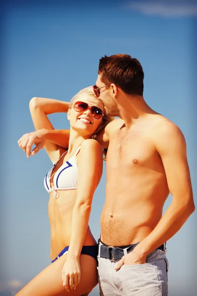 Glückliches Paar mit Sonnenbrille am Strand — Stockfoto