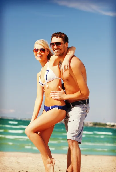 Coppia felice in occhiali da sole sulla spiaggia — Foto Stock