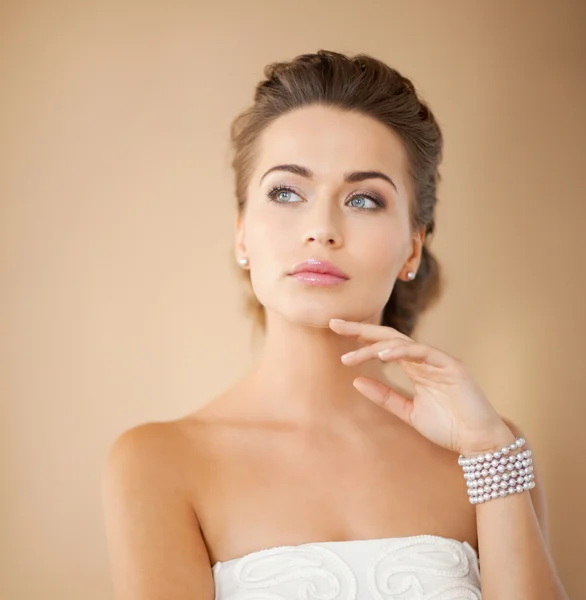 Mujer con pendientes de perlas y pulsera — Foto de Stock