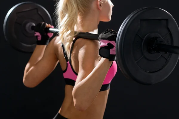 Sporty woman exercising with barbell from back — Stock Photo, Image