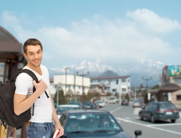 Estudiante viajero con mochila y libro — Foto de Stock