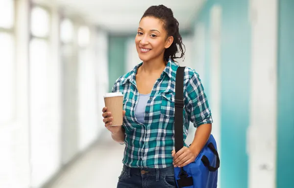 Estudante sorrindo com saco e tirar xícara de café — Fotografia de Stock