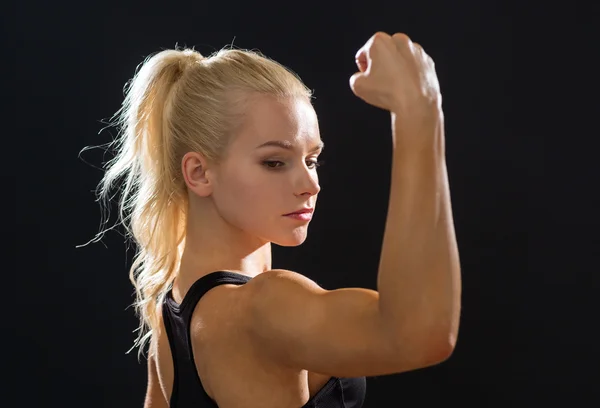 Nahaufnahme einer athletischen Frau, die ihren Bizeps beugt — Stockfoto