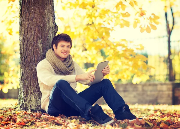 Tablet pc 在秋天的公园里的男人 — 图库照片
