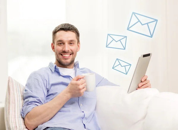 Homme souriant travaillant avec tablette pc à la maison — Photo