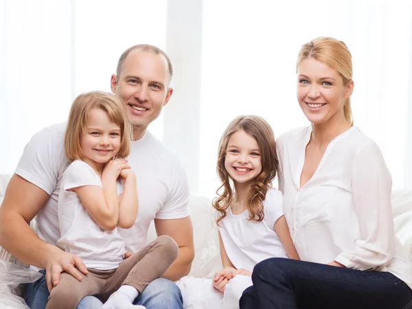 Lächelnde Eltern und zwei kleine Mädchen im neuen Zuhause — Stockfoto