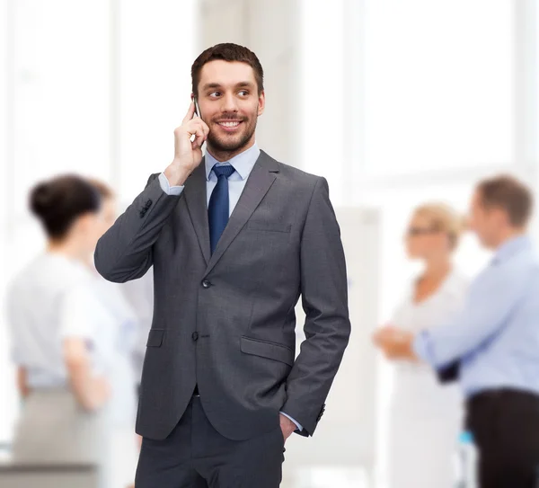 Jovem empresário sorridente com smartphone — Fotografia de Stock