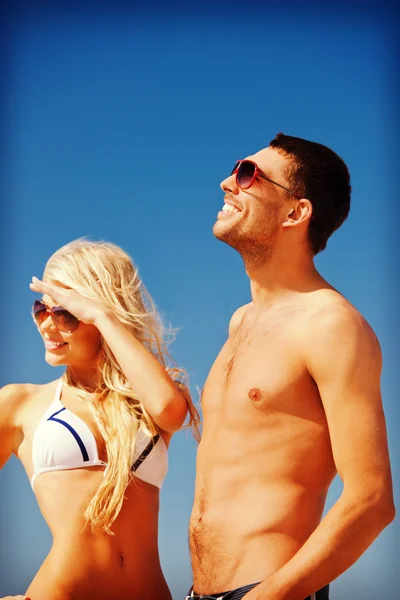 Gelukkige paar in zonnebril op het strand — Stockfoto