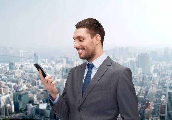 Young smiling businessman with smartphone — Stock Photo, Image