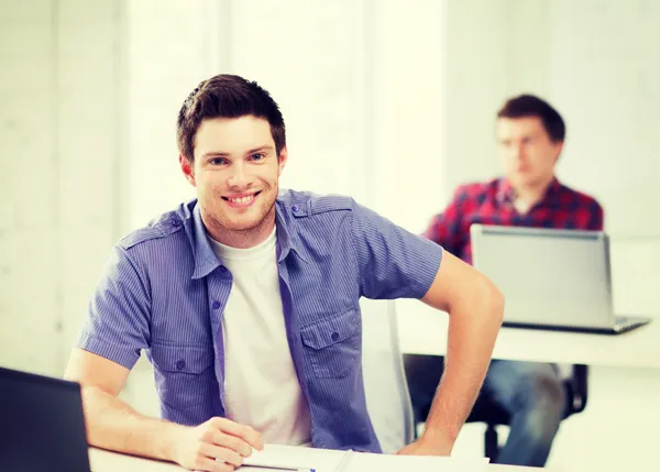 Smiling student with laptop at school — Stok Foto