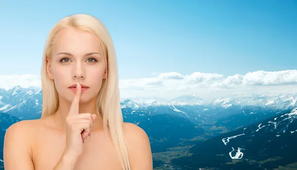 Calm young woman with finger on lips — Stock Photo, Image