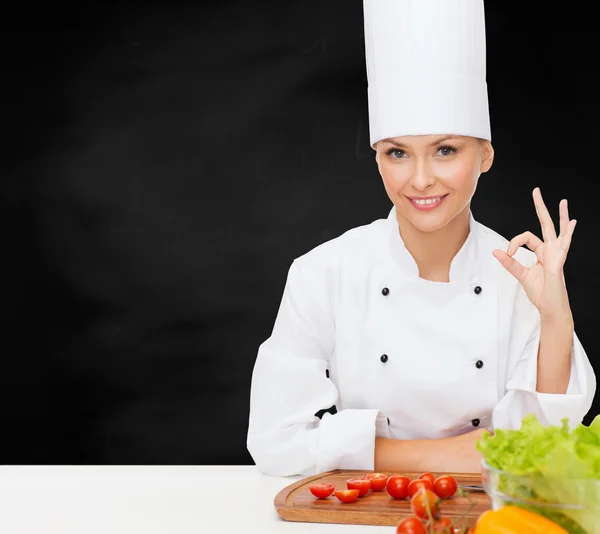 Vrouwelijke chef-kok met groenten weergegeven: ok teken — Stockfoto