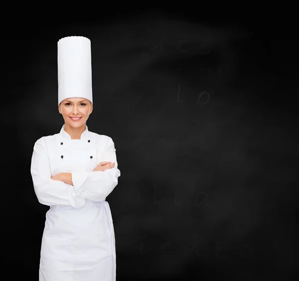 Glimlachend vrouwelijke chef-kok met gekruiste armen — Stockfoto