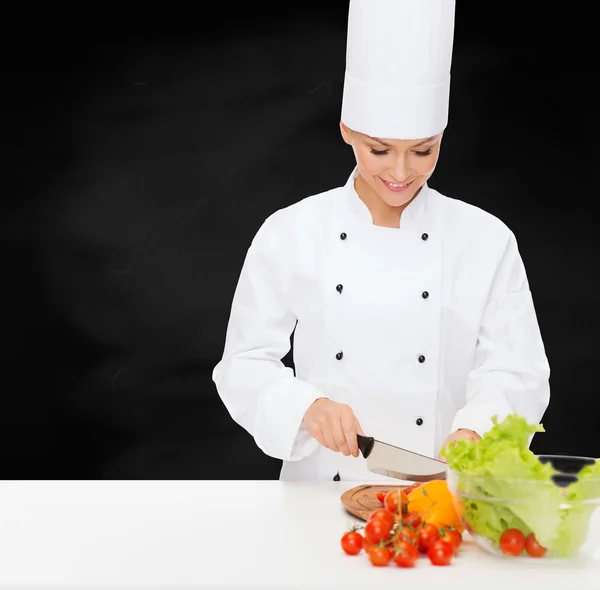 Uśmiechnięta kobieta kucharz do krojenia warzyw — Zdjęcie stockowe