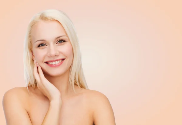 Smiling young woman touching her face skin — Stock Photo, Image