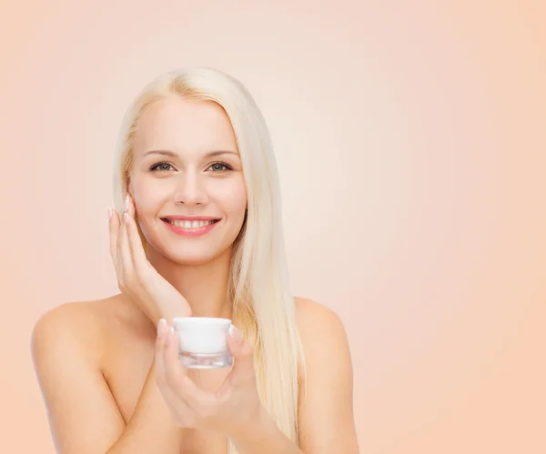 Mujer aplicando crema en su piel — Foto de Stock