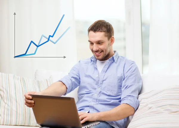 Smiling man working with laptop at home — Stock Photo, Image