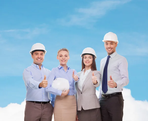 Happy business team in office showing thumbs up — Stock Photo, Image