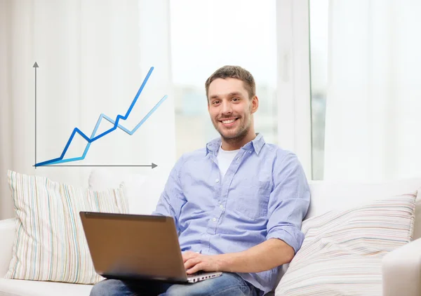 Sorrindo homem trabalhando com laptop em casa — Fotografia de Stock