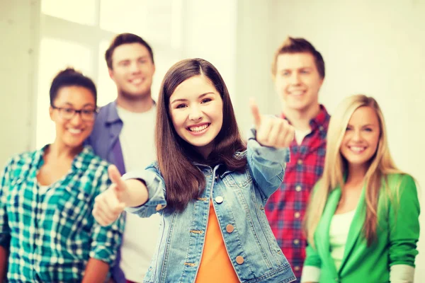 Students showing thumbs up at school — Stock Photo, Image